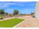 Backyard features artificial turf, desert landscaping and a cornhole game set up on pea gravel at 20151 E Via Del Palo St, Queen Creek, AZ 85142