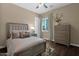 Comfortable bedroom with a soft bed, dresser, and a window that provides natural light at 20151 E Via Del Palo St, Queen Creek, AZ 85142