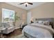 Comfortable bedroom with a gray upholstered headboard and plush armchair near a window at 20151 E Via Del Palo St, Queen Creek, AZ 85142