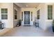 Elegant front porch with a beautifully decorated front door, sconces, potted plants, and outdoor decor at 20151 E Via Del Palo St, Queen Creek, AZ 85142