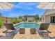 Inviting backyard with a sparkling swimming pool, outdoor fireplace, and relaxing lounge chairs at 20151 E Via Del Palo St, Queen Creek, AZ 85142