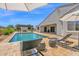 Inviting outdoor space with a sparkling pool, lounge chairs, and a pergola-covered outdoor fireplace at 20151 E Via Del Palo St, Queen Creek, AZ 85142