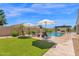 Relaxing backyard pool area with lounge chairs, umbrellas, and lush artificial grass at 20151 E Via Del Palo St, Queen Creek, AZ 85142