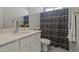 This half-bath features modern fixtures and a sleek black and white shower curtain at 21859 W Gail Dr, Buckeye, AZ 85326