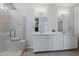 Bright bathroom features a dual sink vanity with quartz countertops and a glass-enclosed shower at 21859 W Gail Dr, Buckeye, AZ 85326