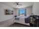 This carpeted bedroom features a ceiling fan, a large window and a wall-mounted TV at 21859 W Gail Dr, Buckeye, AZ 85326