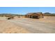 Wide shot of tan single-Gathering home with brown garage door and matching door surrounded by a desert landscape at 21859 W Gail Dr, Buckeye, AZ 85326