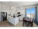 Bright kitchen featuring white cabinets, stainless steel appliances, an island with pendant lighting, and a cozy dining area at 21859 W Gail Dr, Buckeye, AZ 85326