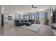Open-concept living room featuring a large gray sofa, white rug, tiled floors, and scenic outdoor views through big windows at 21859 W Gail Dr, Buckeye, AZ 85326