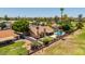 Aerial view of fenced backyard with a private pool, putting green, covered patio, and mature trees at 2448 S Standage --, Mesa, AZ 85202