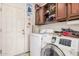 Laundry room featuring a white washer and dryer set, storage cabinets, and access to the garage at 2448 S Standage --, Mesa, AZ 85202