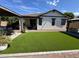 Home backyard featuring synthetic turf, rock landscaping, outdoor dining, and covered patio at 2715 E Canyon Creek Dr, Gilbert, AZ 85295