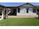 Cozy backyard featuring a covered patio, synthetic grass, and attractive desert landscaping for easy maintenance at 2715 E Canyon Creek Dr, Gilbert, AZ 85295