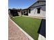 Lush artificial grass in the backyard with a covered patio and grill area at 2715 E Canyon Creek Dr, Gilbert, AZ 85295