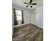 Bedroom with wood-look floors, a ceiling fan, a large window, and a double-door closet for ample storage space at 2715 E Canyon Creek Dr, Gilbert, AZ 85295