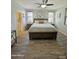 Cozy bedroom featuring a ceiling fan, wood-look tile flooring, and ensuite bathroom at 2715 E Canyon Creek Dr, Gilbert, AZ 85295
