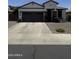 Single story home with a dark garage and neutral tones and rock landscaping at 2715 E Canyon Creek Dr, Gilbert, AZ 85295