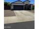 Charming single-story home with a well-manicured front yard, dark two-car garage, and neutral tones at 2715 E Canyon Creek Dr, Gilbert, AZ 85295