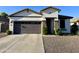 Charming one-story home featuring a gray garage door, stone accents, and low maintenance landscaping at 2715 E Canyon Creek Dr, Gilbert, AZ 85295