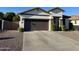 Single-story home with a gray garage door, low maintenance landscaping, and covered entryway at 2715 E Canyon Creek Dr, Gilbert, AZ 85295