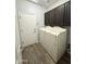 Laundry room with a washer and dryer, gray upper cabinets, wood-look floors, and a door leading outside at 2715 E Canyon Creek Dr, Gilbert, AZ 85295