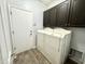 Functional laundry area features a full-size washer and dryer with overhead cabinets, plus exterior access at 2715 E Canyon Creek Dr, Gilbert, AZ 85295