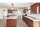 Spacious kitchen features wood cabinets, an island, granite countertops, and stainless steel appliances at 31515 W Buchanan St, Buckeye, AZ 85326