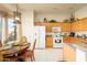 This well-lit eat-in kitchen boasts wooden cabinets, white appliances, and breakfast nook at 316 W Anderson Ave, Phoenix, AZ 85023