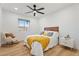 Bright bedroom features wood floors, a ceiling fan, and a large window for natural light at 3506 W Yucca St, Phoenix, AZ 85029