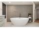 Bright bathroom featuring a luxurious soaking tub with a modern faucet and neutral tile at 41576 N 107Th Way, Scottsdale, AZ 85262
