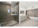 Open bathroom features walk-in shower with bench, a standalone tub, and dual sink vanity with lighted mirrors at 41576 N 107Th Way, Scottsdale, AZ 85262