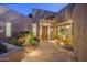 Inviting home entrance with a wooden door, unique stonework, and native desert plants at 41576 N 107Th Way, Scottsdale, AZ 85262