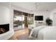 Bright main bedroom with fireplace, white walls, and sliding glass doors overlooking a swimming pool at 41576 N 107Th Way, Scottsdale, AZ 85262