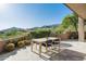 Charming outdoor dining space with a wooden table, surrounded by desert landscaping and scenic mountain views at 41576 N 107Th Way, Scottsdale, AZ 85262