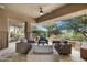 Inviting outdoor seating area under a covered patio, offering a cozy space to enjoy the desert views at 41576 N 107Th Way, Scottsdale, AZ 85262