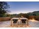 Outdoor dining area with a rustic wooden table and mountain views, perfect for enjoying meals and sunsets at 41576 N 107Th Way, Scottsdale, AZ 85262