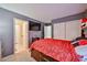 Large bedroom features carpet flooring, gray walls, mounted TV and sliding closet, with bright natural light at 4318 W Apollo Rd, Laveen, AZ 85339