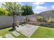 This landscaped backyard features a built-in seating area with a brick paver patio and a lush lawn, creating an inviting outdoor space at 455 W Evergreen Pear Ave, Queen Creek, AZ 85140