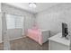 Cozy bedroom with gray walls, carpet, a large window, and a twin bed with pink blanket at 455 W Evergreen Pear Ave, Queen Creek, AZ 85140