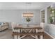 Dining area with a wooden table, bench seating, upholstered chairs, modern lighting and greenery at 455 W Evergreen Pear Ave, Queen Creek, AZ 85140