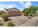 Single-story home with desert landscaping, brick driveway, and a two-car garage at 455 W Evergreen Pear Ave, Queen Creek, AZ 85140