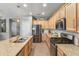 Bright kitchen featuring wooden cabinets, stainless steel appliances, granite countertops, a kitchen island, and tile floors at 455 W Evergreen Pear Ave, Queen Creek, AZ 85140