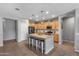Spacious kitchen featuring wooden cabinetry, stainless steel appliances, an island with seating, and modern lighting fixtures at 455 W Evergreen Pear Ave, Queen Creek, AZ 85140