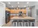 Well-lit kitchen with wood cabinets, stainless steel appliances, and a large granite island with barstool seating at 455 W Evergreen Pear Ave, Queen Creek, AZ 85140