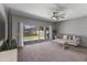 Spacious living room with plush carpet, neutral décor, ceiling fan, and sliding glass doors leading to the patio at 455 W Evergreen Pear Ave, Queen Creek, AZ 85140