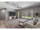 Bright living room featuring a ceiling fan, cozy seating, large sliding glass doors, and access to the backyard at 455 W Evergreen Pear Ave, Queen Creek, AZ 85140