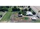 Aerial shot showcasing a home with adjacent sheds and extensive farmland, bordered by lush trees at 5016 W Sunrise Dr, Laveen, AZ 85339