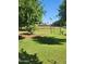Large backyard with lush green grass, mature trees, and garden area, perfect for outdoor living at 5016 W Sunrise Dr, Laveen, AZ 85339