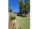 Rustic barn featuring natural wood posts and tin roof is set amongst a vibrant green lawn with healthy tree coverage at 5016 W Sunrise Dr, Laveen, AZ 85339