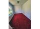 Cozy room with a window providing backyard view and red carpeting at 5016 W Sunrise Dr, Laveen, AZ 85339